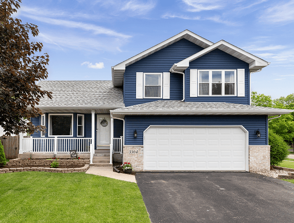 Exterior of a suburban home with blue siding, a white front porch, and white shutters.